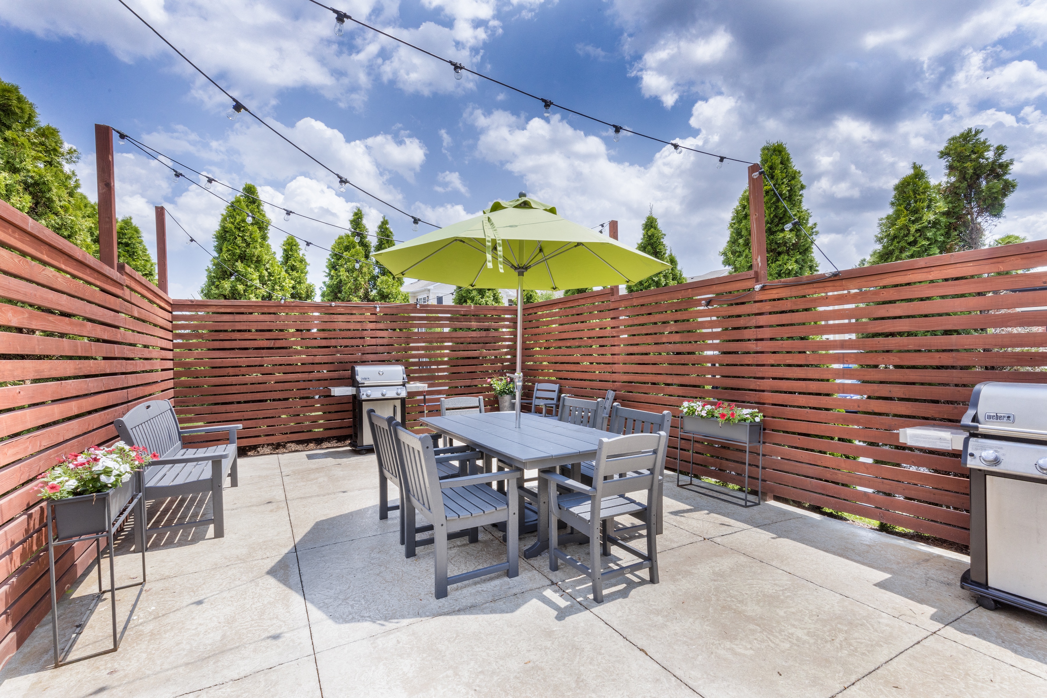 a patio with a table and chairs and an umbrella at Aventura at Forest Park, St. Louis, MO 63110